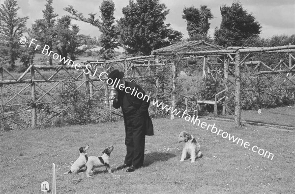 PRIEST AT PAROCHIAL HOUSE WITH DOGS